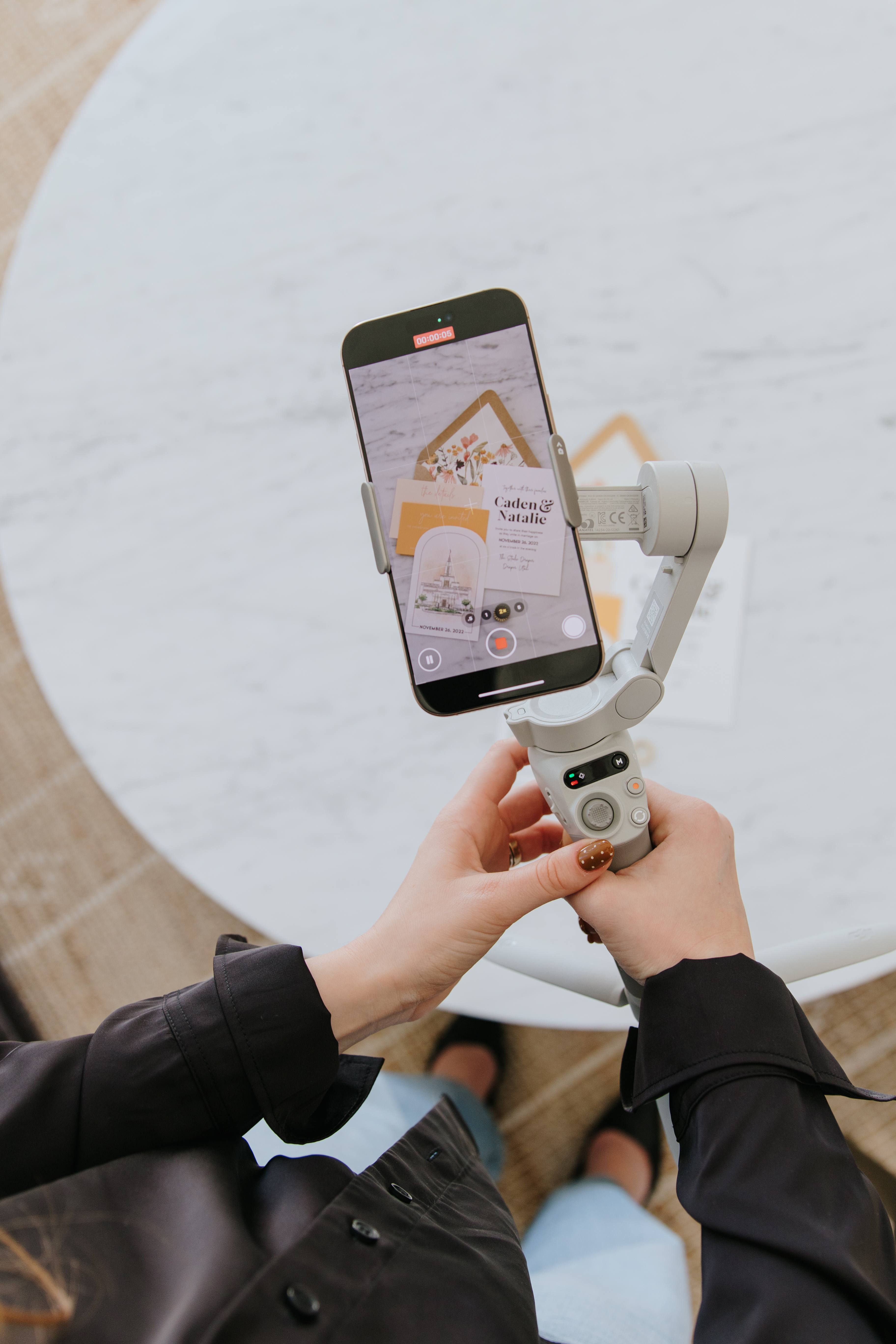 Phone, gimbal, and stationery arranged for behind-the-scenes brand content